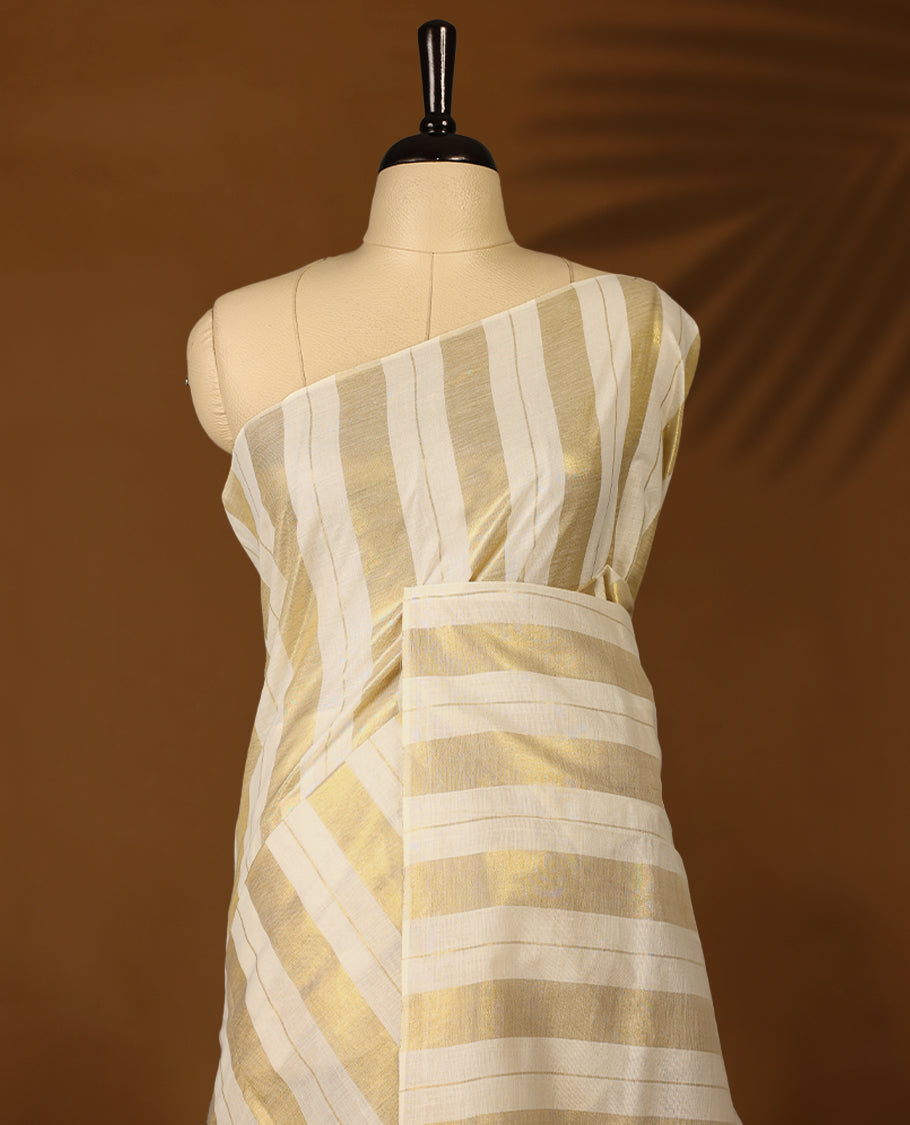 White & gold colour striped Kerala saree featuring  a sheer, smooth body, without border, Comes paired with a coordinated matching blouse.