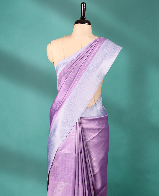 Violet coloured semi silk saree featuring a Silver coloured Zari design on the body, paired with a Baby Blue coloured border and matching blouse.