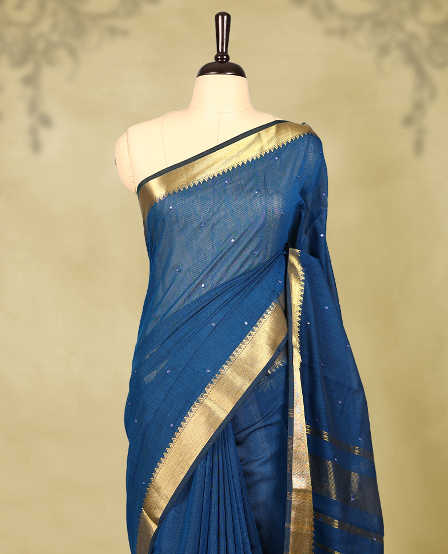 Blue colour Chanderi cotton saree featuring a subtly textured body with delicate buti work, complemented by a rich golden zari border with matching blouse