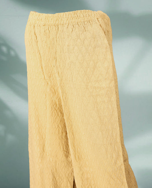 Beige colour palazzo pants featuring intricate self embroidery and a relaxed, flowy fit