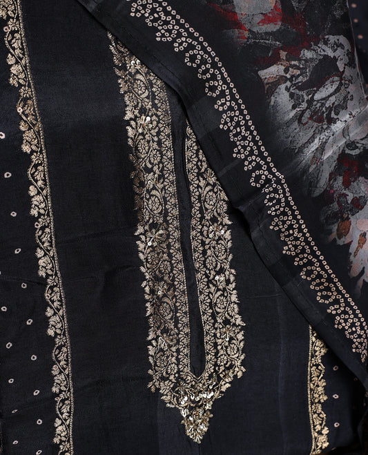Black colour churidhar material highlighted with elegant zari embroidery on the neckline, paired with a plain matching bottom and a floral printed dupatta with dotted accents.