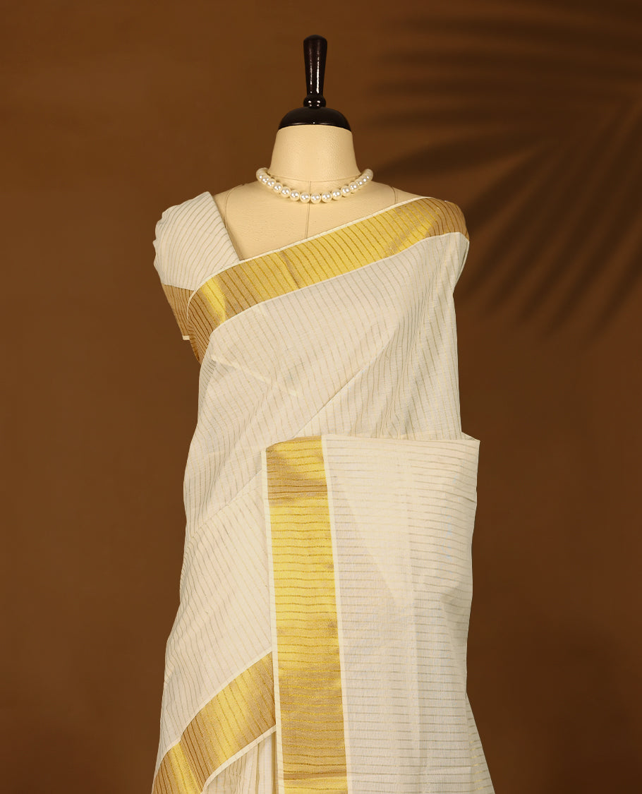 Off White Kerala Kasavu saree featuring a broad golden zari border with subtle striped detailing, paired with a matching blouse