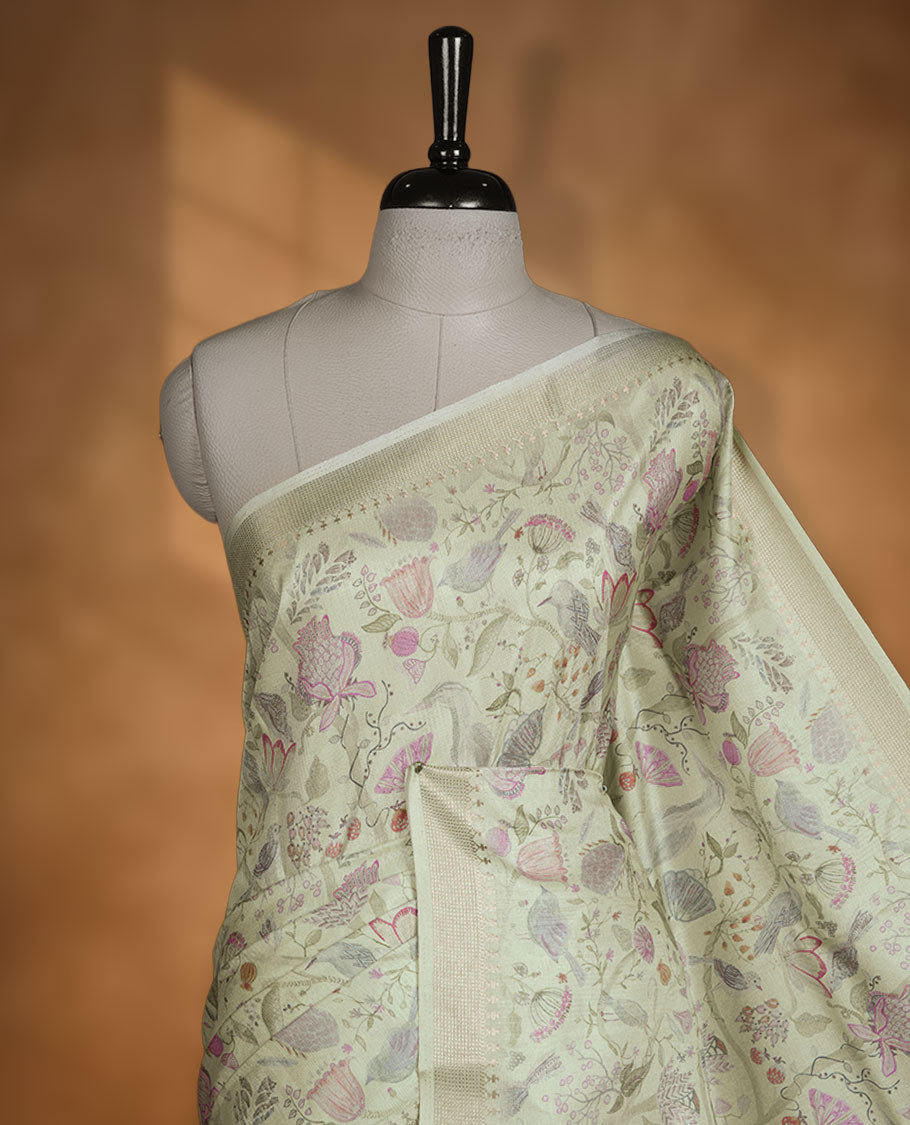 Light green colour semi tussar silk saree featuring all over floral and leaf motifs on the body with a subtle self border and tasselled pallu, paired with a matching blouse.