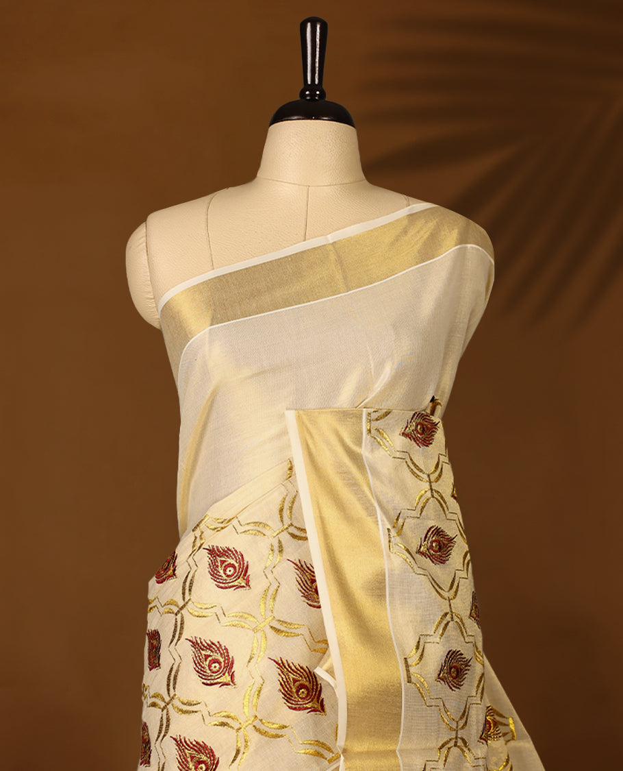 Elegant Light Gold colour Tissue Kerala saree featuring peacock feather embroidery worked body and traditional golden zari kasavu border offering a classic and graceful look, paired with a matching blouse.