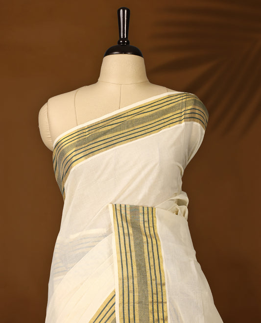 Elegant off white colour cotton Kerala saree with a soft cream body, adorned with traditional golden zari work,It features a green and gold striped border, offering a perfect blend of simplicity and festive charm & Includes blouse piece.