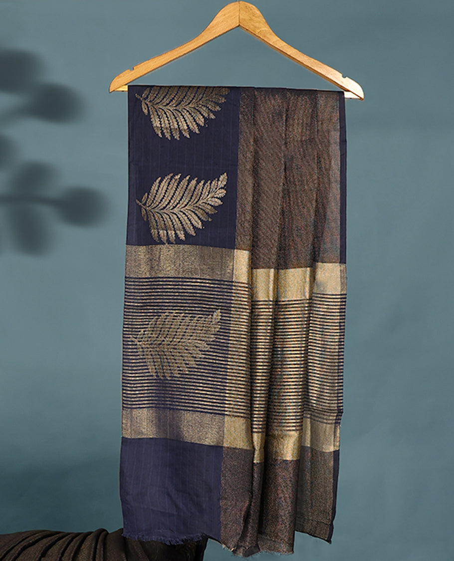 Navy Blue Colour Semi Tussar Silk saree featuring golden zari horizontal lines across the body, adorned with bold Leaf motifs on the border, paired with a matching blouse.