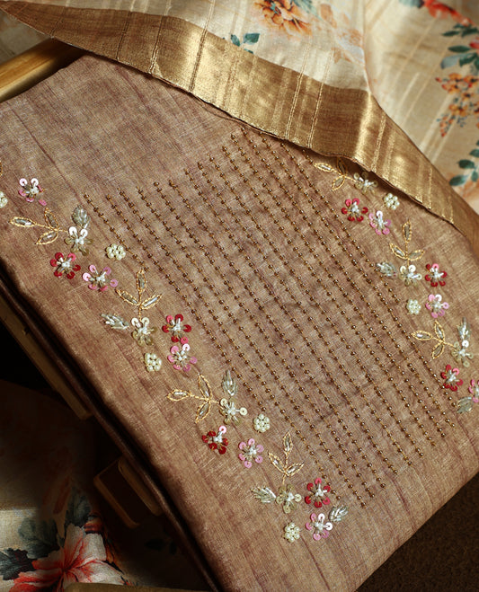 Flaxen yellow colour churidhar material adorned with floral embroidery and sewn glass beads on the yoke, paired with a plain bottom and same colour dupatta featuring floral prints.