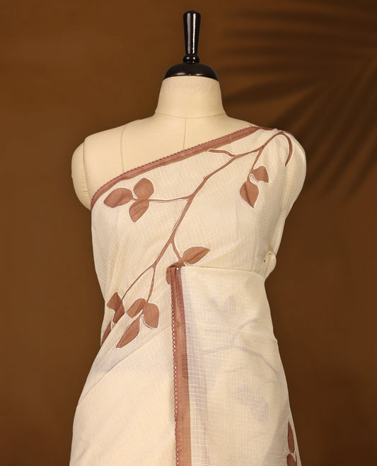 Cream colour Tussar cotton Kota saree featuring delicate Block printed leaves motifs across the body, highlighted with a subtle brown border, paired with a matching blouse.