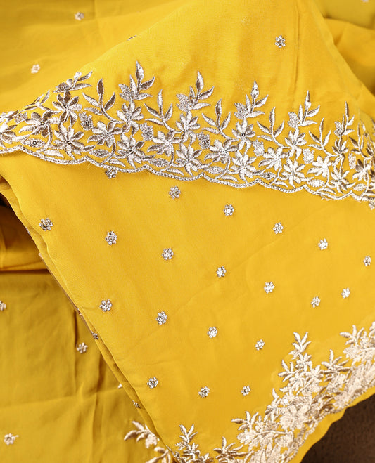 Yellow colour churidhar material adorned with elegant golden floral embroidery and delicate motifs, paired with a matching embroidered dupatta and plain bottom.