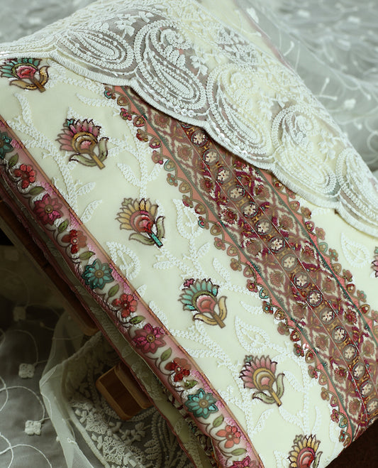 Cream colour churidhar material with embroidered neck work, white threadwork on the body, and multicolor floral motifs in pink, green & yellow & Comes with matching plain bottom and embroidered dupatta.