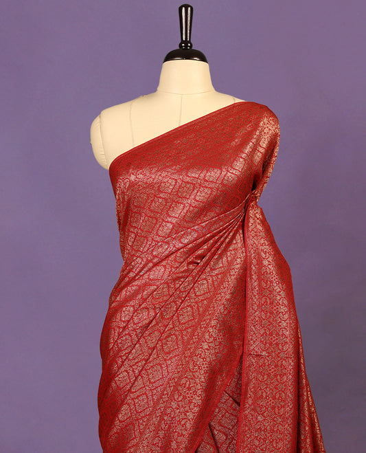 Deep Red colour semi Banaras Katan saree featuring an antique Gold zari jacquard body, complemented by a self colour traditional border with a floral kodi design, paired with a matching blouse