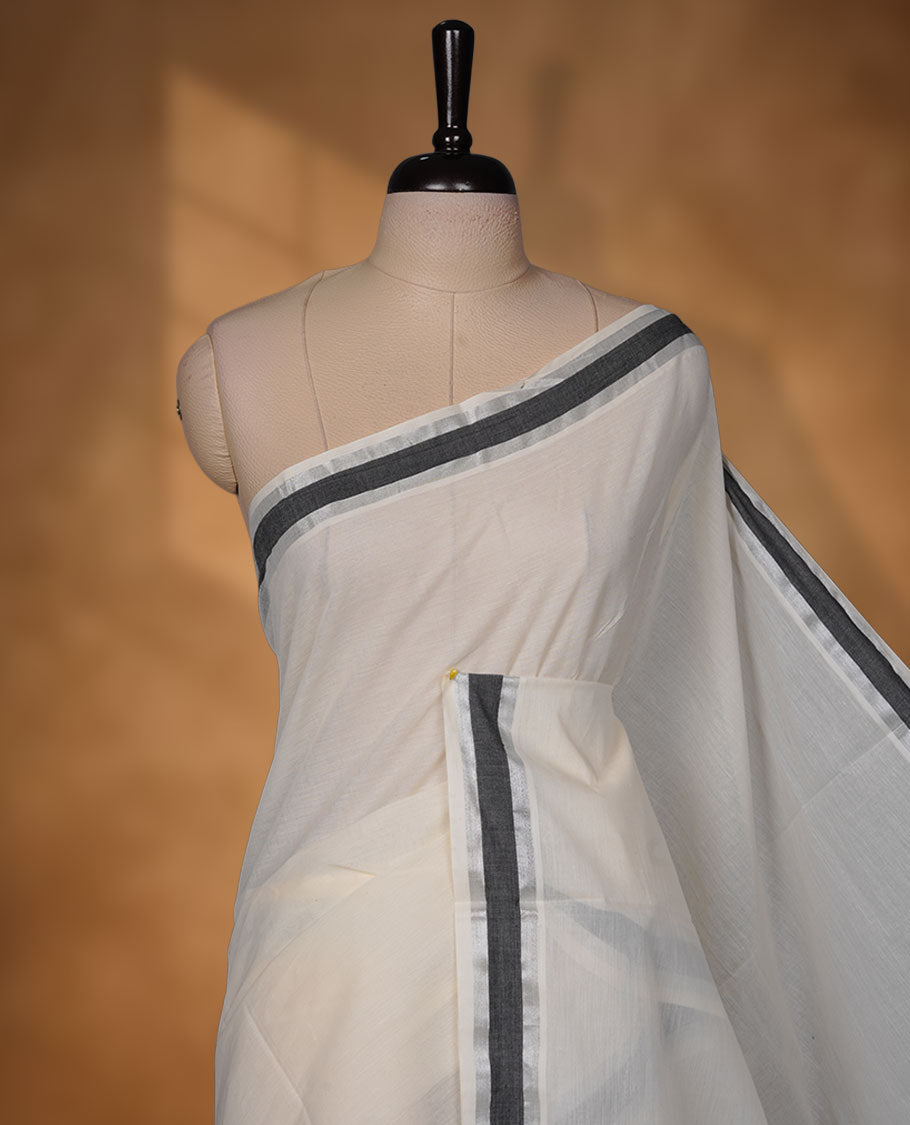Off-white colour cotton Kerala saree with a subtle silver and black kasavu border, featuring a clean plain body, paired with a matching blouse.