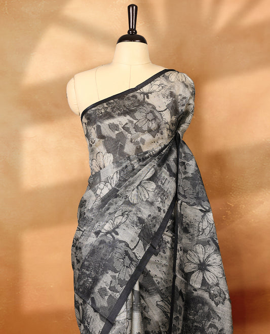 Black colour pure tussar silk light weight saree with full body abstract off white colour floral print, no defined border and pallu, paired with matching abstract printed blouse.