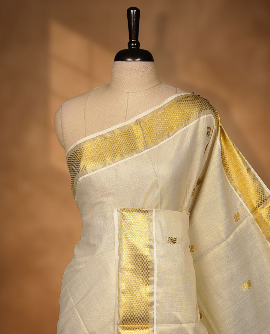 Light gold tissue Kerala saree featuring a softly shimmering body with delicate gold zari buttas, a refined kasavu border, and an intricately woven traditional pallu, paired with a matching blouse.