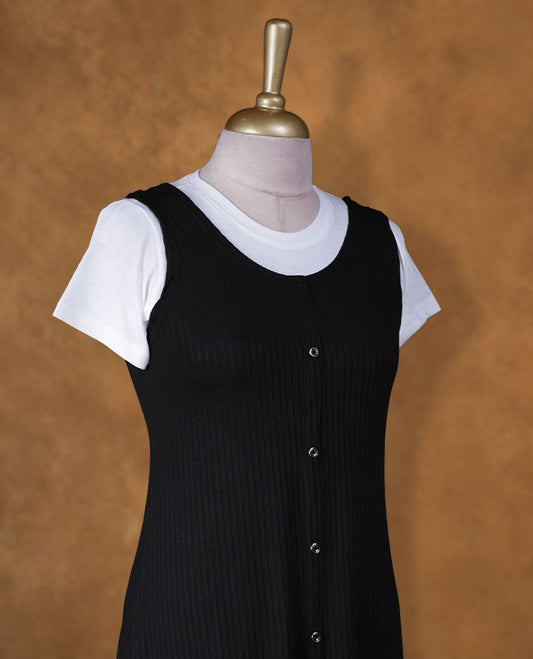 Black sleeveless A-line midi dress with front button detailing, layered over a white crew-neck short-sleeve inner tee