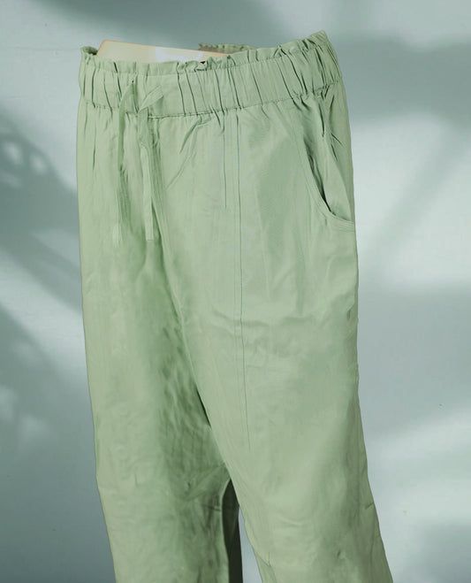 Light sage green colour women's pants feature a relaxed, ankle length fit with an elastic waistband, subtle pleats, and side pockets