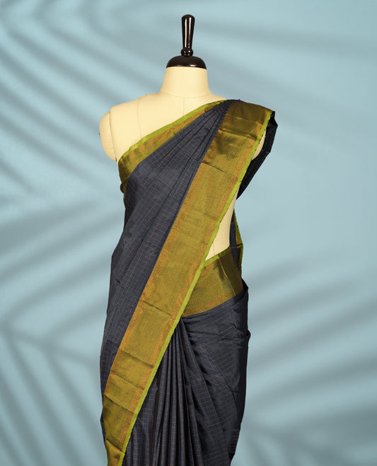 Charcoal grey Colour semi silk saree features a subtle copper zari check pattern, beautifully accented with a copper & olive green border, and comes with a matching blouse