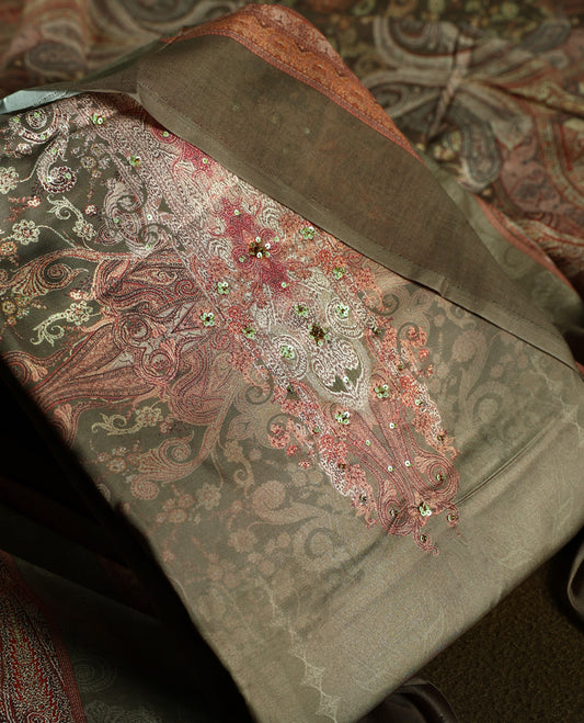 Earthy olive green colour churidhar material featuring intricate embroidery with subtle paisley patterns, paired with a richly printed dupatta and plain bottom.