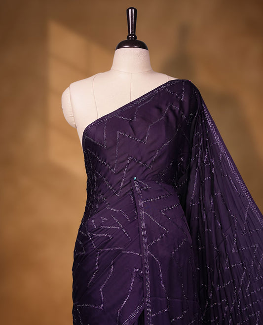 Dark violet Colour shimmer fancy saree adorned with red stone buttas all over the body, paired with a delicate stone worked border and matching blouse featuring floral vine stone embroidery