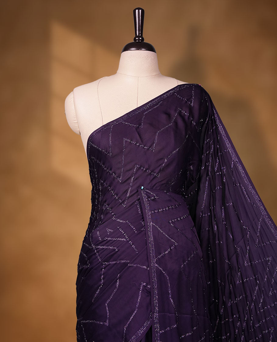 Dark violet Colour shimmer fancy saree adorned with red stone buttas all over the body, paired with a delicate stone worked border and matching blouse featuring floral vine stone embroidery