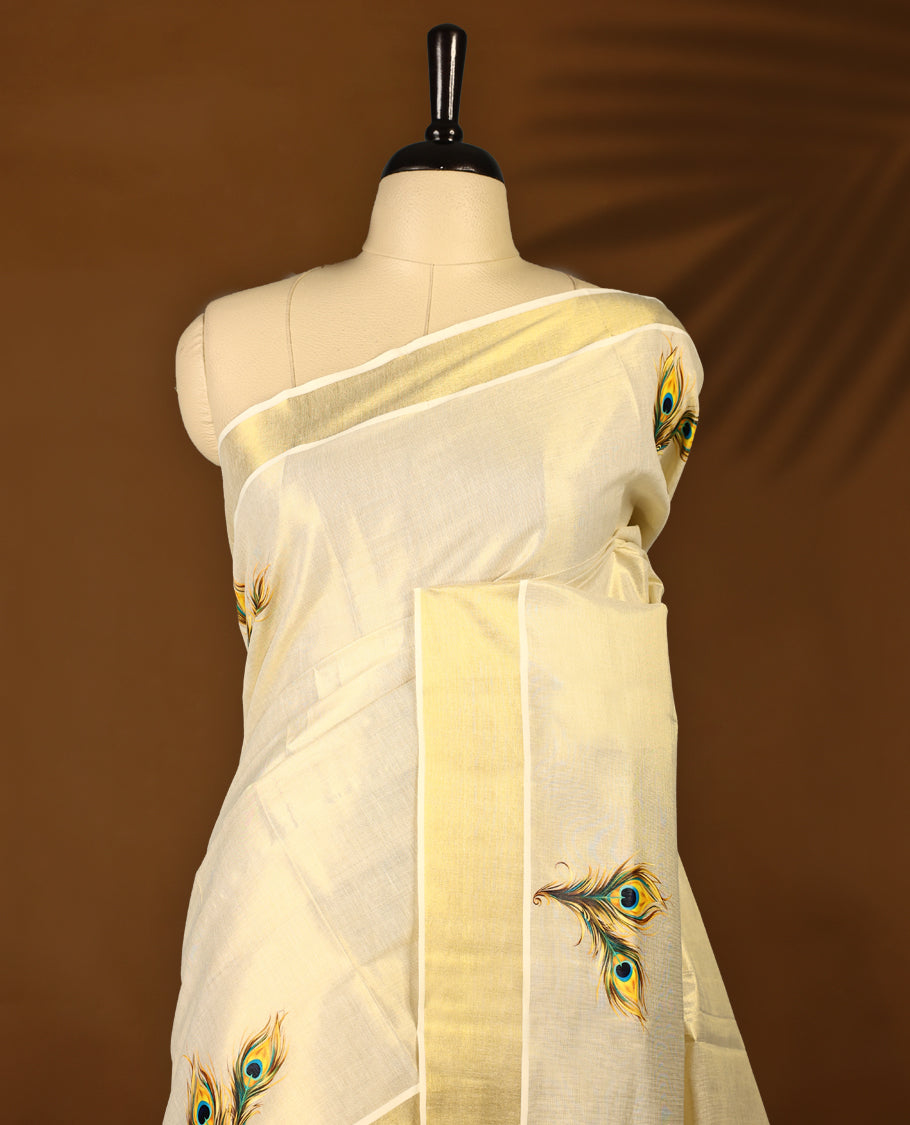 Light Gold colour Tissue Kerala saree featuring Peacock feather prints on body and a beautifully woven Gold Kasavu border, paired with a matching blouse perfect for festive occasions.