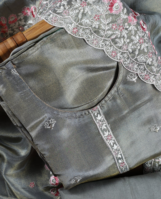 Grey colour churidar material adorned with delicate floral thread embroidery in white and pink, paired with a plain matching bottom and embroidered dupatta, perfect for festive occasions and celebrations.