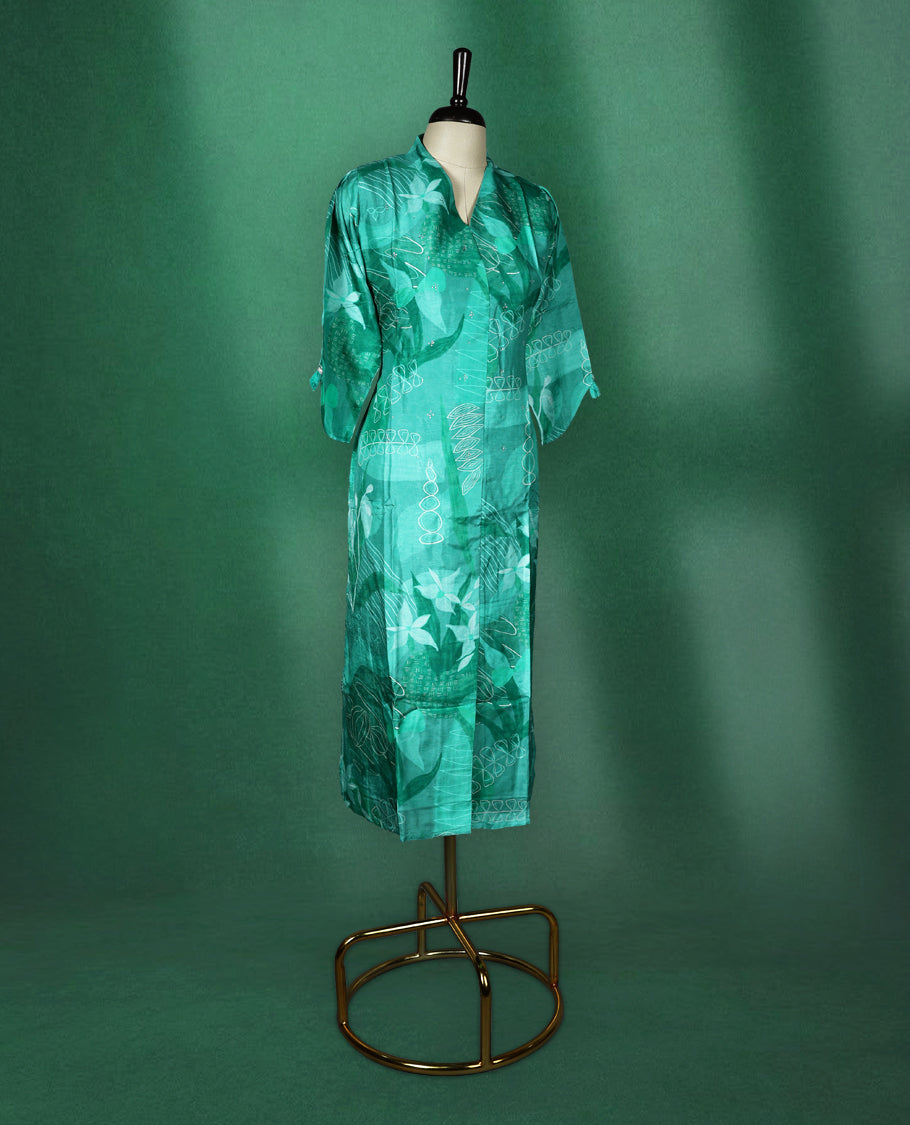 Teal green straight cut kurti with tonal abstract prints and delicate stone work on the body, featuring a V neck with notched collar and elbow length sleeves with button tabs.