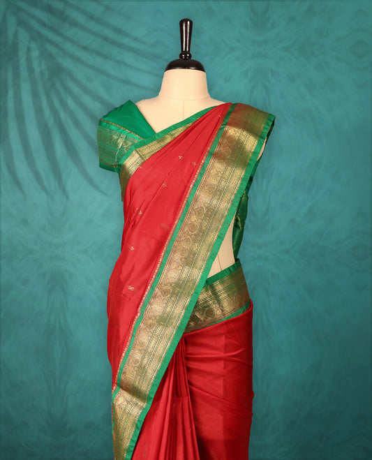 Deep Red colour Traditional Kancheepuram Silk saree with small gold motifs on body, Green traditional border with intricate gold zari weaving, grand zari pallu, perfect for Bharatanatyam, with matching blouse.