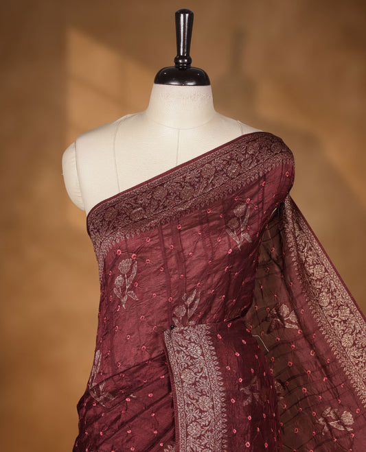 Deep brown colour Banarasi Bandhani silk saree featuring with intricate Banarasi motifs on body, complemented by antique zari woven border and grand pallu, paired with matching  blouse