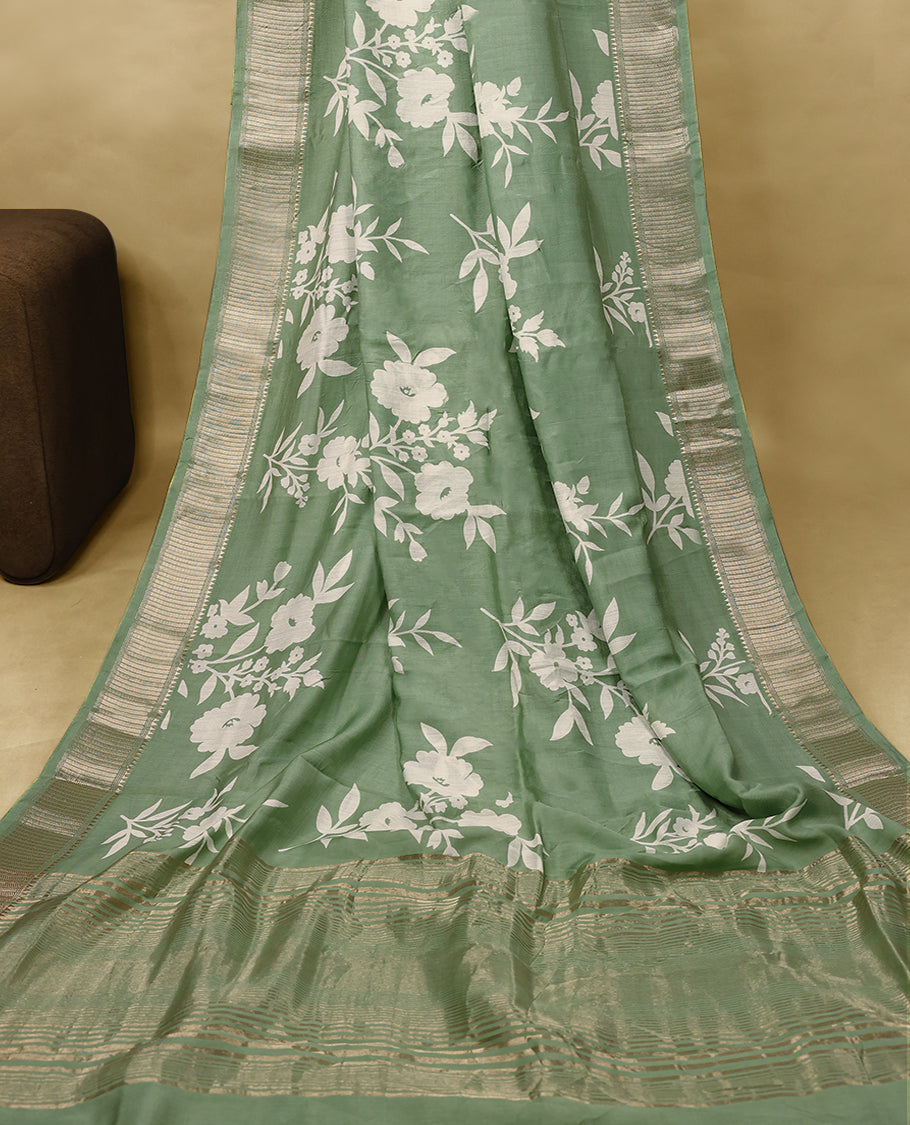 Soft sage green colour Viscos semi printed saree featuring a golden zari border, white floral printed motifs on the body, and comes with a matching blouse