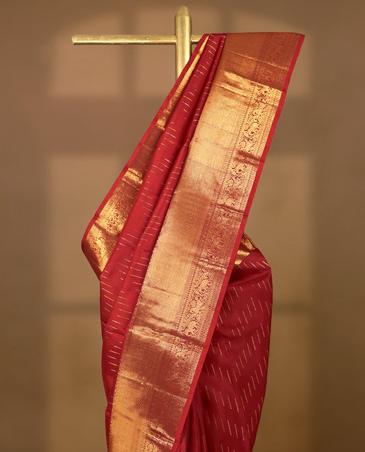 Deep red Colour pure traditional Kancheepuram silk saree adorned with intricately woven antique zari work on the body, complemented by Self colour traditional border featuring elephant, Horse, and Floral Kodi motifs, and paired with a matching blouse.