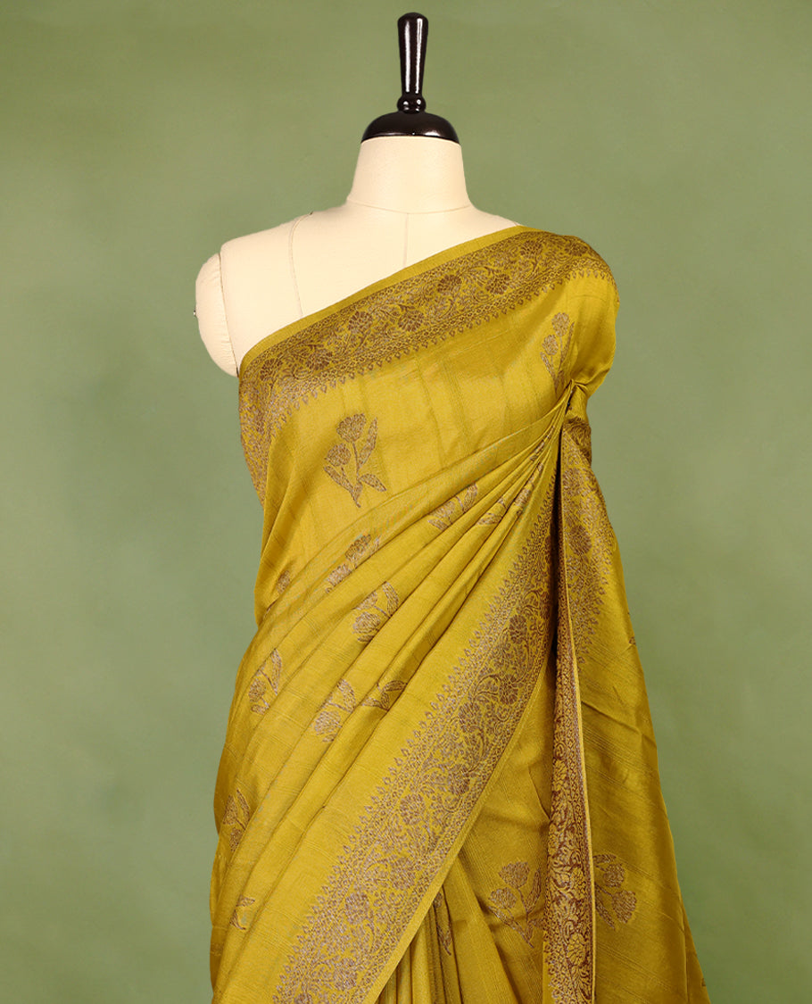 Dark Mustard colour semi Banaras tussar georgette saree embellished with antique zari flower motifs across the body, complemented by a rich Banaras border and paired with a matching blouse.