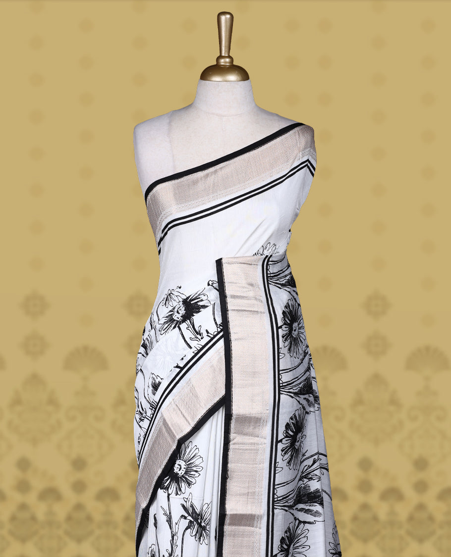 White colour saree with black floral and geometric prints, featuring a contrast zari border and beautifully detailed printed pallu & Comes with a matching blouse piece.