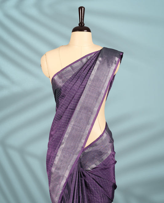 Dusty purple colour semi silk saree featuring silver checkered weave patterns on the body, complemented by a sleek silver zari border, and comes with a matching blouse.