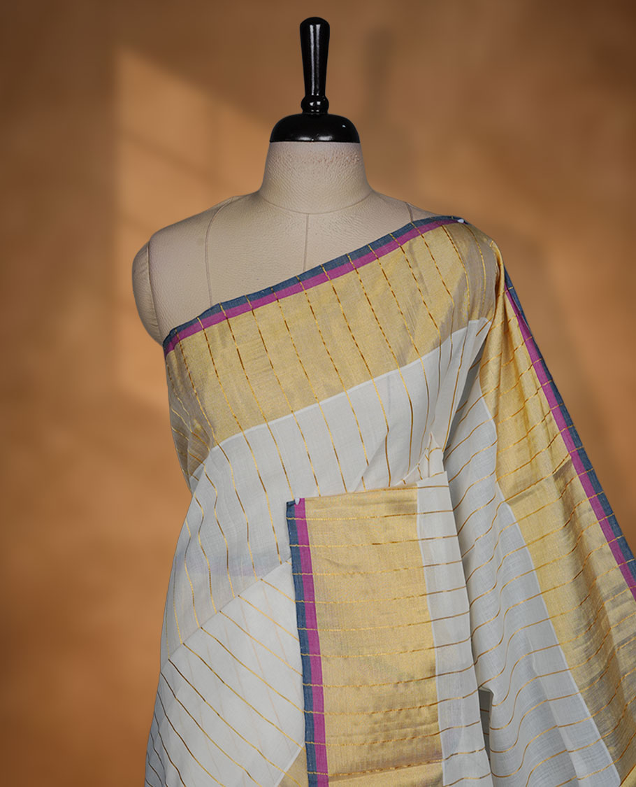 Off-white colour kerala saree with fine gold stripes, rich zari border and pallu highlighted by elegant pink and blue edging, paired with a matching blouse.