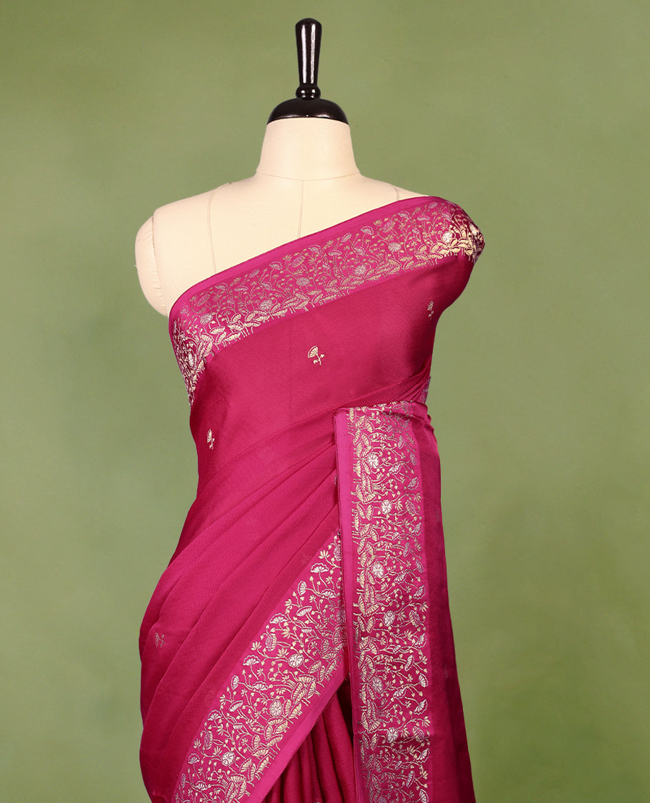 Magenta colour pure Banaras crepe saree showcases elegant Gold zari Flower Motifs all over the body, a traditional gold & Silver zari border, a rich intricately woven pallu, and comes with a matching blouse.
