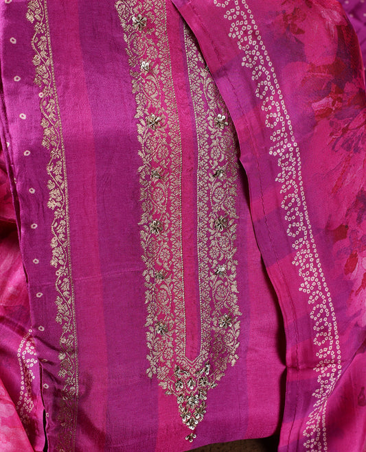 Radiant magenta colour churidhar material adorned with intricate zari embroidery on the neckline, paired with a plain bottom and a floral printed dupatta with dotted accents.