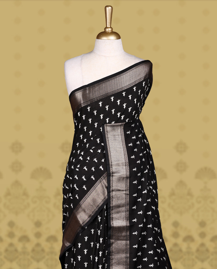 Black colour saree adorned with elegant white floral prints and a rich black zari border and rich stripped pallu & Comes with a matching blouse piece.