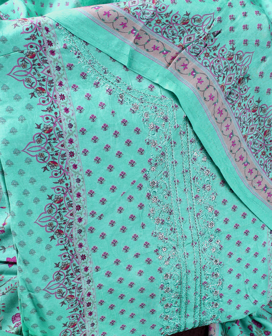 Sea green colour churidhar material featuring delicate peach prints and fine embroidery on the neckline, paired with a matching printed dupatta and plain bottom.