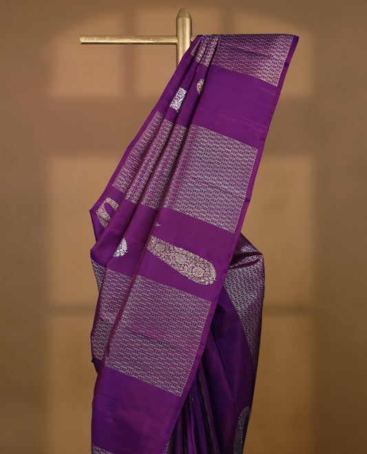 Deep royal purple Colour Kancheepuram designer saree adorned with antique zari large mango motifs, floral kodi work, and vertical gold zari lines on the body, designed without a border, and paired with a matching blouse.