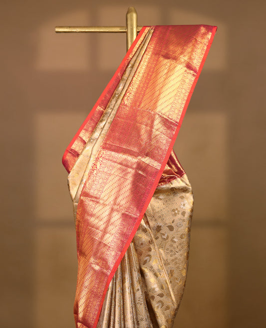 Gold colour tissue brocade saree with gold and silver zari floral kodi design on body, gold zari floral and peacock work pinkish orange border, rich matching pallu with Antique zari motifs, paired with matching blouse.