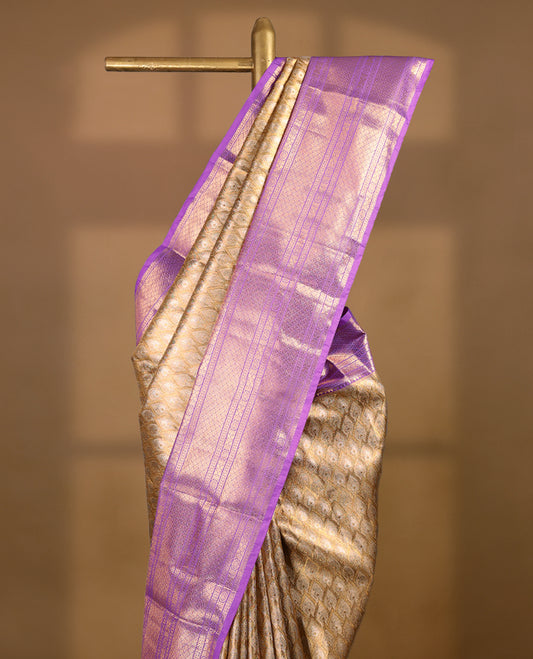Gold colour tissue brocade saree with gold and silver zari pattern on body, gold zari traditional floral kodi work lavender border, rich matching pallu with Antique zari motifs, paired with matching blouse.