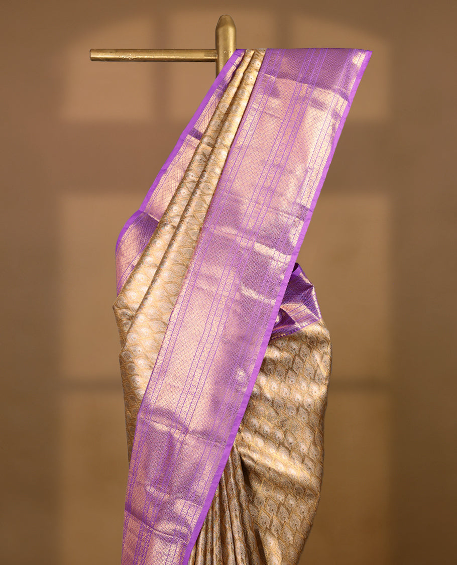 Gold colour tissue brocade saree with gold and silver zari pattern on body, gold zari traditional floral kodi work lavender border, rich matching pallu with Antique zari motifs, paired with matching blouse.