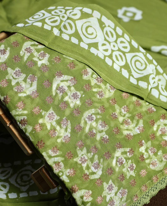 Light green colour churidhar material adorned with gold and copper toned floral patterns and bold block designs, paired with a plain matching bottom and stylish dupatta, perfect for festive evenings and traditional gatherings.