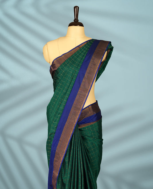 Green Colour semi silk saree features golden thread checks all over, complemented by a rich contrast blue and Golden zari border, and comes with a matching blouse.