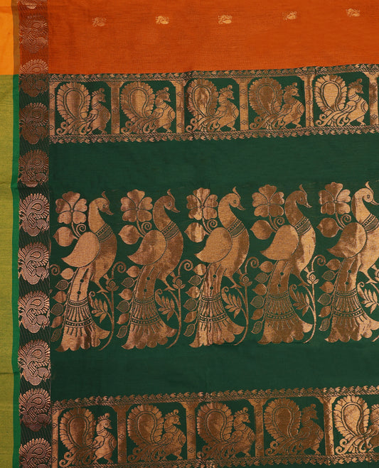 Rust Orange colour mixed Kalyani cotton saree featuring Copper zari Peacock motifs throughout the body, paired with Bottle Green colour traditional border and pallu, with matching blouse