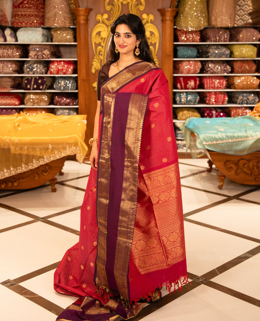 Magenta with Purple Chettinad cotton saree featuring Gold zari strips with peacock motifs on body, complemented by contrast colour border with zari design & grand pallu, comes with matching blouse piece.