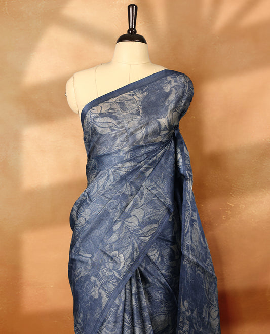 Blue colour pure tussar silk light weight saree with full body abstract floral print, no defined border and pallu, paired with matching abstract printed blouse.