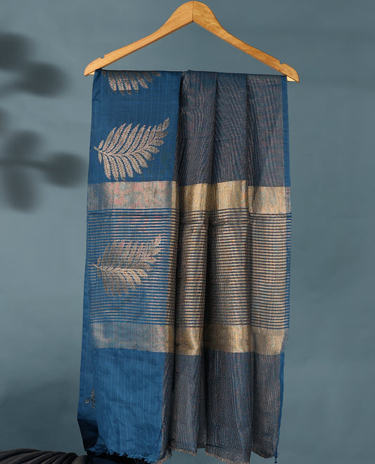 Blue Colour Semi Tussar Silk saree featuring golden zari horizontal lines across the body, adorned with bold Leaf motifs on the border, paired with a matching blouse.