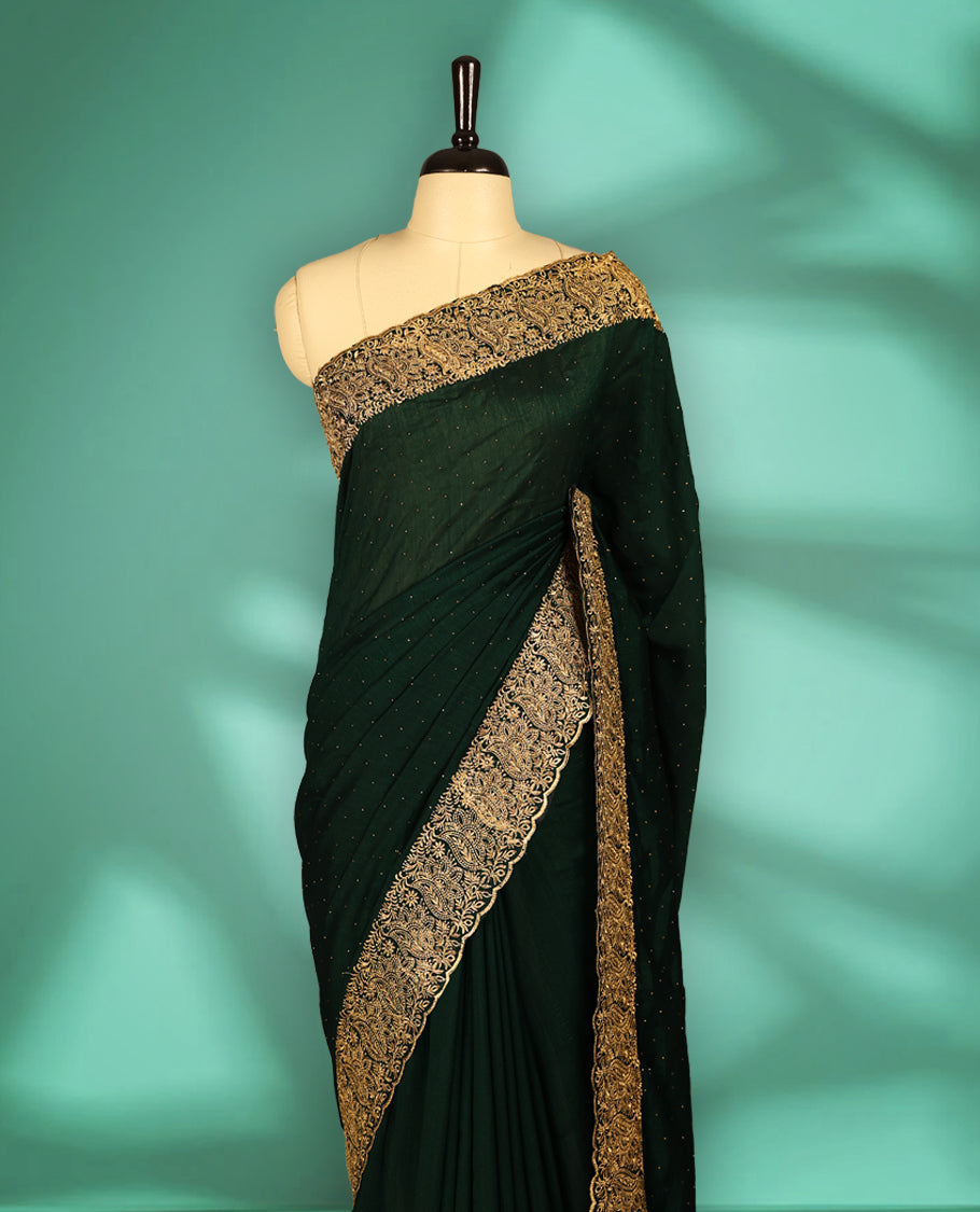 Bottle Green colour Vichitra silk fancy saree featuring tiny stone embellishments across the body, accentuated with a heavy floral embroidery border in gold thread, with matching blouse